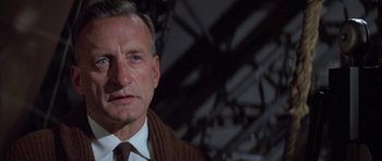 Movie still from “The Hindenburg” (1975), directed by Robert Wise – An older man wearing a sweater and a tie; Close Up shot, Low angle