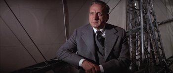 Movie still from “The Hindenburg” (1975), directed by Robert Wise – An older man wearing a suit and tie; Close Up shot, Low angle