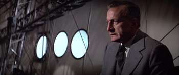 Movie still from “The Hindenburg” (1975), directed by Robert Wise – An older man in a suit and tie looking off into the distance; Close Up shot, Low angle