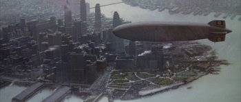 Movie still from “The Hindenburg” (1975), directed by Robert Wise – An aerial view of a large city with buildings; Extreme Wide shot, Overhead angle