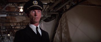 Movie still from “The Hindenburg” (1975), directed by Robert Wise – A person wearing a uniform and a hat; Close Up shot, Low angle