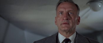 Movie still from “The Hindenburg” (1975), directed by Robert Wise – A person wearing a suit and tie; Close Up shot, Low angle