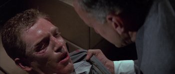 Movie still from “The Hindenburg” (1975), directed by Robert Wise – A man is getting his face waxed by another man; Close Up shot, Low angle