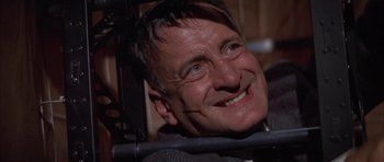 Movie still from “The Hindenburg” (1975), directed by Robert Wise – A person smiling; Close Up shot, Low angle