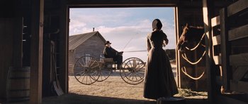 Movie still from “The Homesman” (2014), directed by Tommy Lee Jones – A man and a woman riding in a horse drawn carriage; Wide shot, Low angle