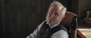 Movie still from “The Homesman” (2014), directed by Tommy Lee Jones – An old man with a white beard wearing a vest and tie; Close Up shot, Over the shoulder angle