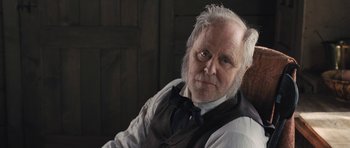 Movie still from “The Homesman” (2014), directed by Tommy Lee Jones – An older man wearing a vest and a bow tie; Close Up shot, Over the shoulder angle