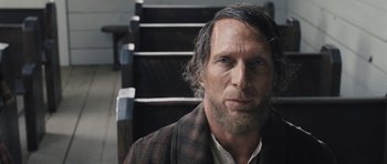 Movie still from “The Homesman” (2014), directed by Tommy Lee Jones – A person wearing a suit and tie; Close Up shot, Over the shoulder angle