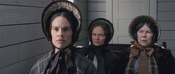 Movie still from “The Homesman” (2014), directed by Tommy Lee Jones – Two women in period costumes are standing next to each other; Close Up shot, Low angle