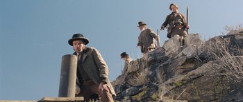 Movie still from “The Homesman” (2014), directed by Tommy Lee Jones – A group of men climbing up a mountain; Wide shot, Low angle