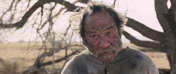 Movie still from “The Homesman” (2014), directed by Tommy Lee Jones – An old man with a beard is looking at the camera; Close Up shot, Low angle
