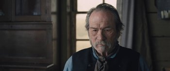 Movie still from “The Homesman” (2014), directed by Tommy Lee Jones – An older man wearing a neck tie in front of a window; Close Up shot, Over the shoulder angle
