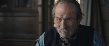 Movie still from “The Homesman” (2014), directed by Tommy Lee Jones – An old man with a beard and a tie; Close Up shot, Over the shoulder angle