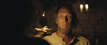 Movie still from “The Homesman” (2014), directed by Tommy Lee Jones – A man with long hair and a goatee smoking a cigarette; Close Up shot, Over the shoulder angle