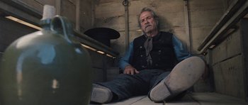 Movie still from “The Homesman” (2014), directed by Tommy Lee Jones – An older man sitting on the floor of a building; Medium shot, Low angle
