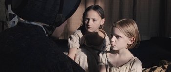 Movie still from “The Homesman” (2014), directed by Tommy Lee Jones – Two young girls are sitting in a room; Close Up shot, Over the shoulder angle