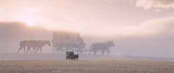 Movie still from “The Homesman” (2014), directed by Tommy Lee Jones – Two horses pulling a covered wagon on a dirt field; Extreme Wide shot, Low angle