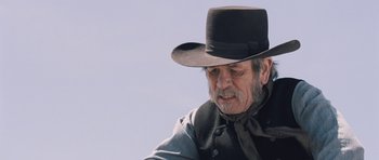 Movie still from “The Homesman” (2014), directed by Tommy Lee Jones – An older man wearing a hat and a tie; Close Up shot, Over the shoulder angle