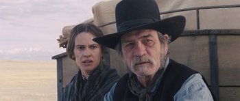 Movie still from “The Homesman” (2014), directed by Tommy Lee Jones – A man and a woman standing next to each other; Close Up shot, Over the shoulder angle
