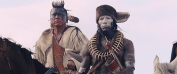 Movie still from “The Homesman” (2014), directed by Tommy Lee Jones – A couple of native americans standing next to each other; Medium shot, Low angle