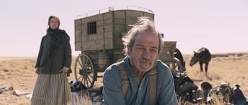 Movie still from “The Homesman” (2014), directed by Tommy Lee Jones – An older man sitting in front of a horse drawn carriage; Close Up shot, Low angle