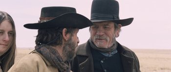 Movie still from “The Homesman” (2014), directed by Tommy Lee Jones – A man in a cowboy hat talking to another man in a cowboy hat; Close Up shot, Over the shoulder angle
