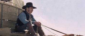 Movie still from “The Homesman” (2014), directed by Tommy Lee Jones – An older man sitting on a horse in a field; Medium shot, Low angle