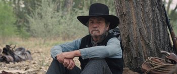 Movie still from “The Homesman” (2014), directed by Tommy Lee Jones – An old man sitting on the ground next to a tree; Close Up shot, Low angle