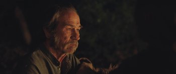 Movie still from “The Homesman” (2014), directed by Tommy Lee Jones – An old man with a beard is sitting in the dark; Close Up shot, Over the shoulder angle