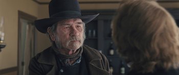 Movie still from “The Homesman” (2014), directed by Tommy Lee Jones – An older man wearing a black hat and a brown jacket; Close Up shot, Over the shoulder angle