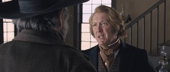 Movie still from “The Homesman” (2014), directed by Tommy Lee Jones – A man with long blonde hair wearing a black jacket; Close Up shot, Over the shoulder angle