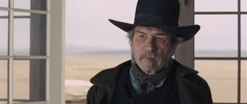 Movie still from “The Homesman” (2014), directed by Tommy Lee Jones – An older man wearing a black hat and a black jacket; Close Up shot, Over the shoulder angle