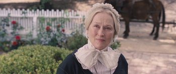 Movie still from “The Homesman” (2014), directed by Tommy Lee Jones – An older woman wearing a hat and a neck tie; Close Up shot, Over the shoulder angle