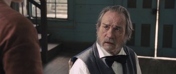 Movie still from “The Homesman” (2014), directed by Tommy Lee Jones – An older man wearing a vest and a tie; Close Up shot, Over the shoulder angle