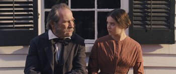 Movie still from “The Homesman” (2014), directed by Tommy Lee Jones – An older man and a young woman sitting next to each other; Medium shot, Over the shoulder angle