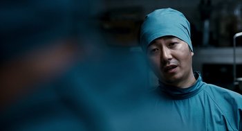 Movie still from “The Host” (2006), directed by Bong Joon Ho – A man wearing a surgical gown and a hat; Close Up shot, Over the shoulder angle
