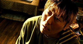 Movie still from “The Host” (2006), directed by Bong Joon Ho – A person wearing a green shirt; Close Up shot, High angle