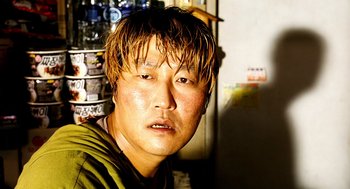 Movie still from “The Host” (2006), directed by Bong Joon Ho – A person wearing a green shirt; Close Up shot, Low angle
