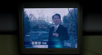 Movie still from “The Host” (2006), directed by Bong Joon Ho – A man in a suit and tie holding a cell phone in his hand; Extreme Close Up shot, Low angle