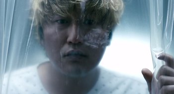 Movie still from “The Host” (2006), directed by Bong Joon Ho – A man with blonde long hair and a white shirt; Extreme Close Up shot, Low angle