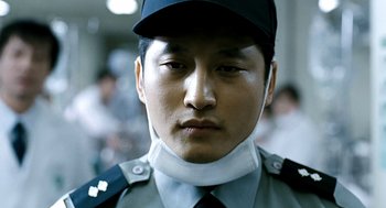 Movie still from “The Host” (2006), directed by Bong Joon Ho – A person wearing a uniform; Close Up shot, Low angle