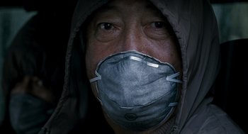 Movie still from “The Host” (2006), directed by Bong Joon Ho – A man wearing a surgical face mask and a hood; Close Up shot, Low angle