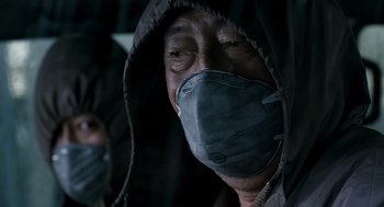 Movie still from “The Host” (2006), directed by Bong Joon Ho – A man wearing a surgical mask while wearing a hooded jacket; Close Up shot, Low angle