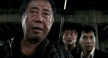 Movie still from “The Host” (2006), directed by Bong Joon Ho – A group of men standing next to each other in a room; Close Up shot, Low angle