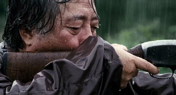 Movie still from “The Host” (2006), directed by Bong Joon Ho – A man in a rain jacket holding his head in his hands; Extreme Close Up shot, Low angle