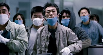 Movie still from “The Host” (2006), directed by Bong Joon Ho – A group of people wearing masks while standing in a crowd; Medium shot, Low angle