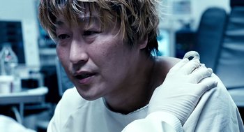 Movie still from “The Host” (2006), directed by Bong Joon Ho – A person wearing a white shirt; Close Up shot, Over the shoulder angle