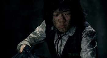 Movie still from “The Host” (2006), directed by Bong Joon Ho – A person with a knife in their hand; Close Up shot, High angle