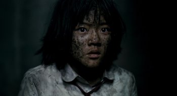 Movie still from “The Host” (2006), directed by Bong Joon Ho – A young person with black hair and a white shirt; Close Up shot, High angle