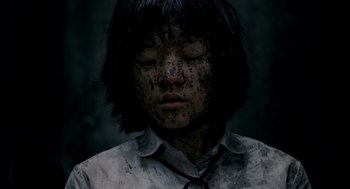 Movie still from “The Host” (2006), directed by Bong Joon Ho – A person with dirt all over their face and neck; Close Up shot, Overhead angle